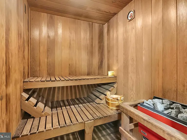 Indoor cedar sauna with tiered benches and heated stones
